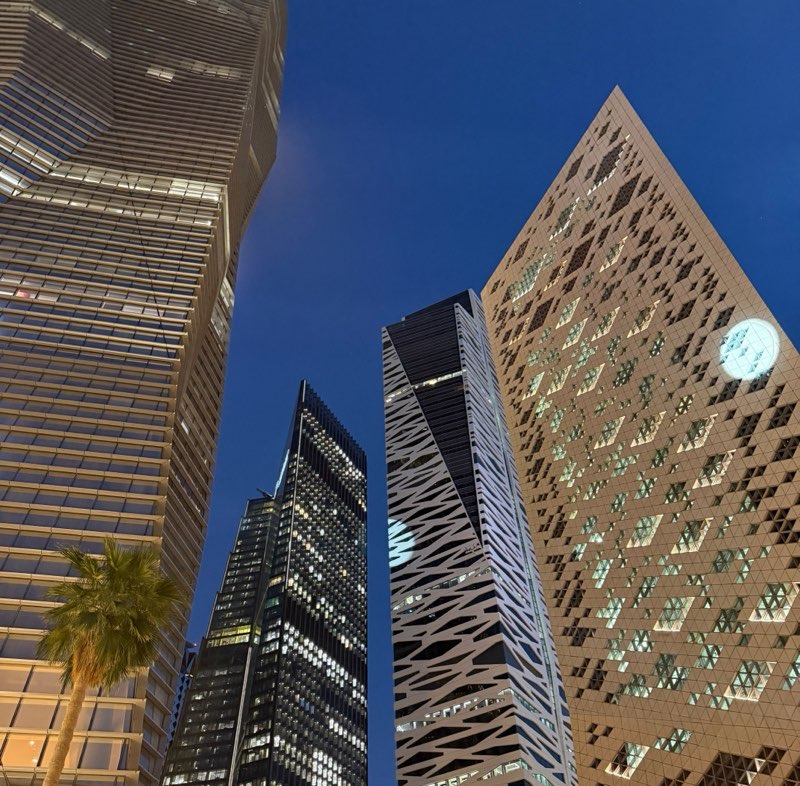 Illuminated towers of a Gulf financial district at dusk