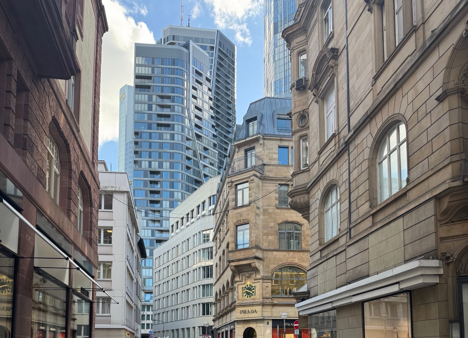 Glass towers above period facades in a narrow financial-district street